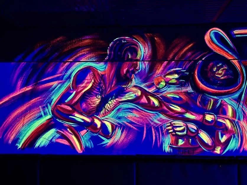 Neon-style mural of Jesus Christ and a snake, with bright, vibrant colors and abstract swirling backgrounds.