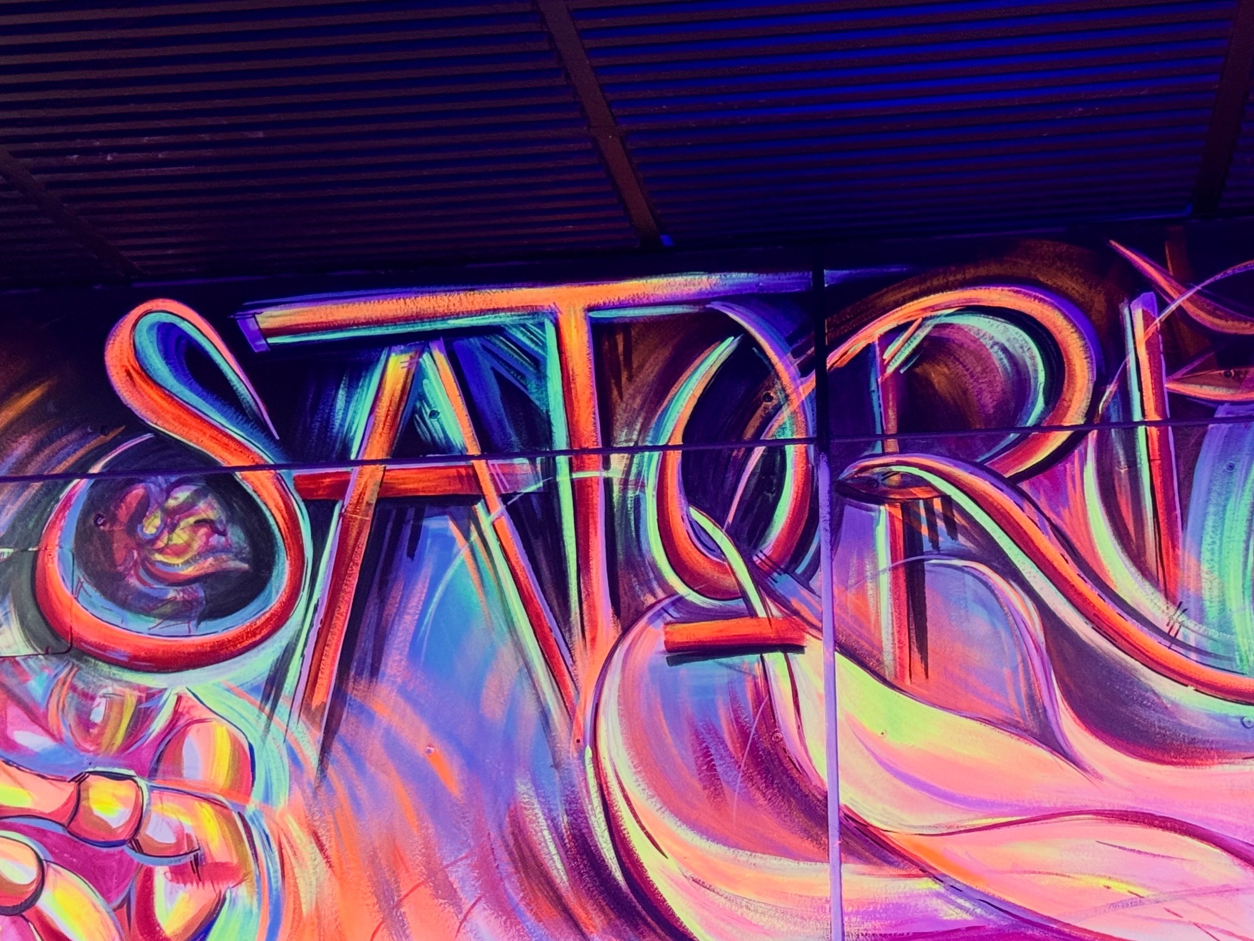 Colorful neon graffiti art with the word 'STOP' partially visible in bright, swirling colors.