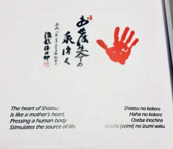 A red handprint and Japanese calligraphy with English translation about the heart of Shiatsu and its connection to life and the human body.