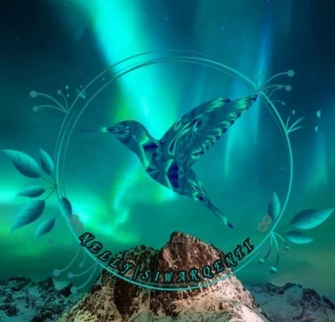 Hummingbird flying in front of the northern lights over a mountain