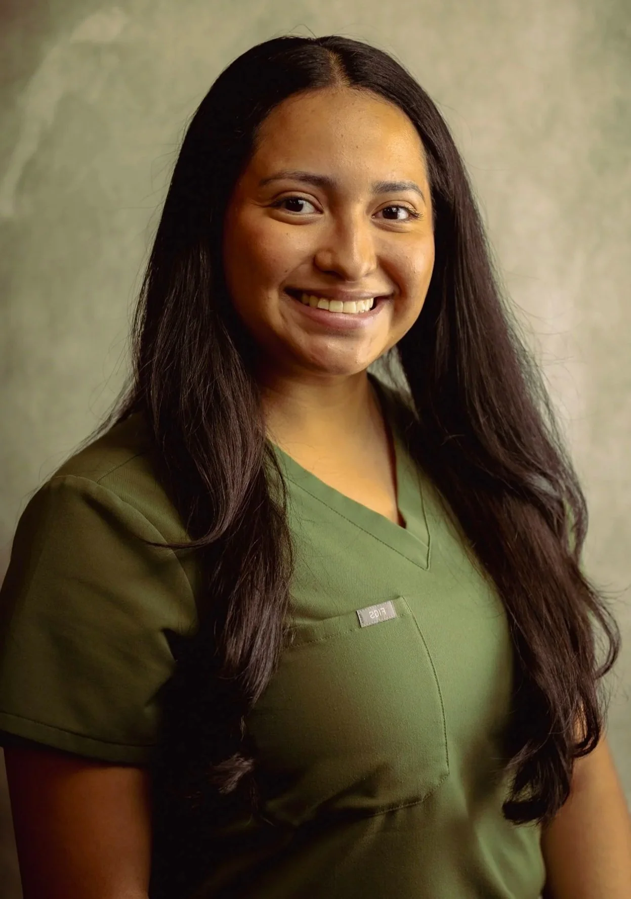 Dental assistant at Smiles of North Dallas dental office in Dallas, TX in Richardson, TX wearing green FIGS scrubs.