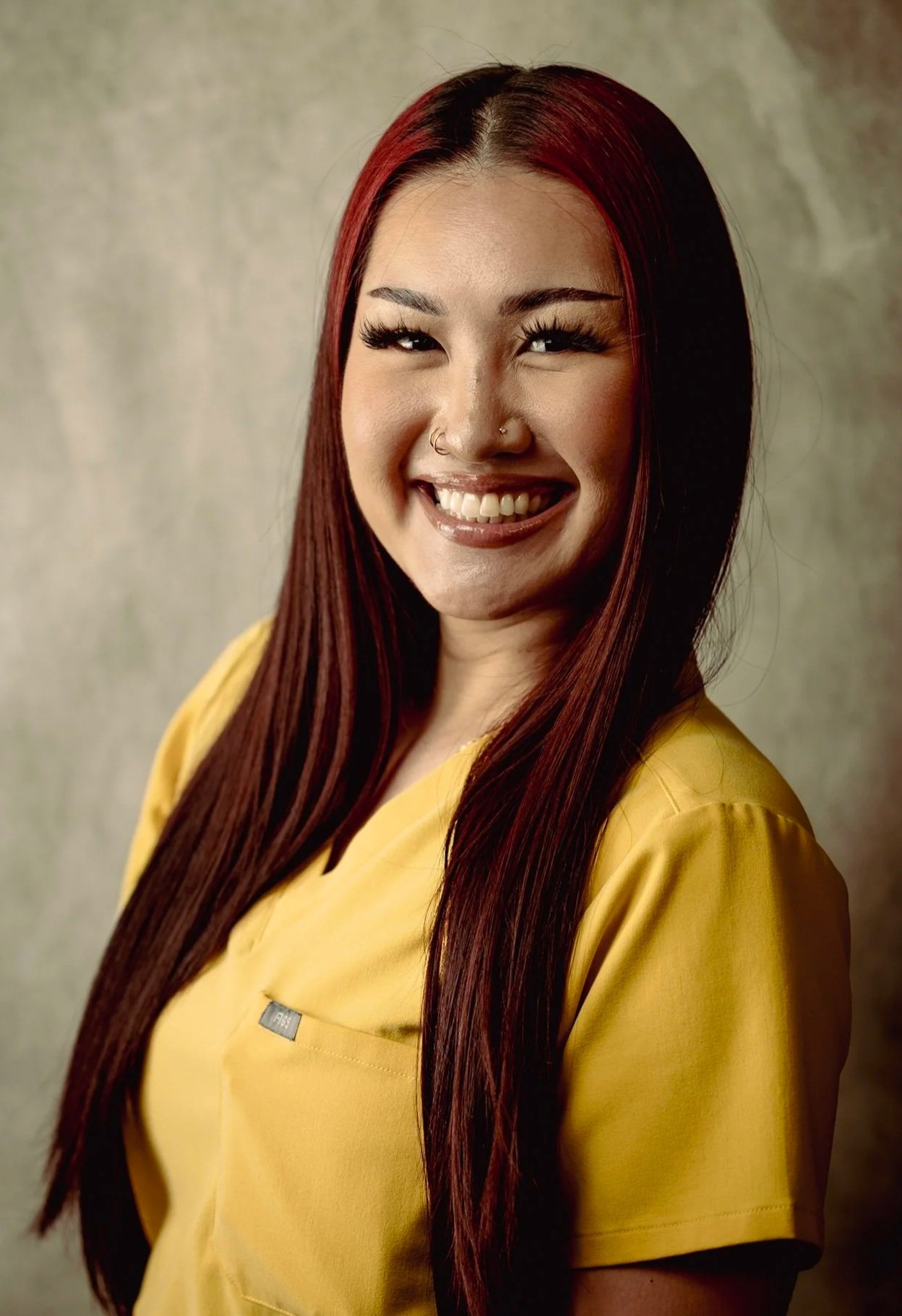Dental assistant at Smiles of North Dallas dental office in Plano, TX in Dallas, TX wearing yellow FIGS scrubs.