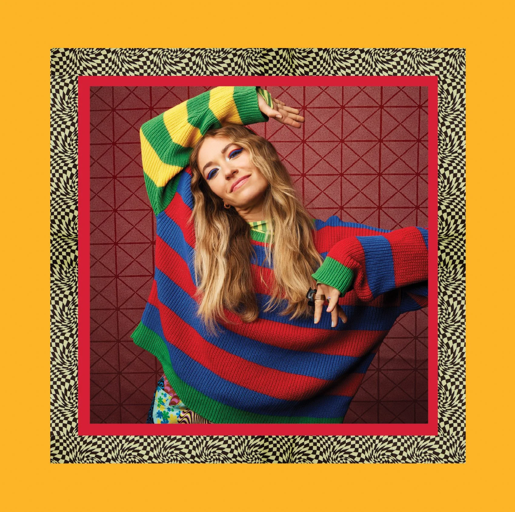 A woman with long curly hair wearing a colorful striped sweater and vibrant patterned pants lying on a geometric maroon and black background, surrounded by black and white checkered and wavy patterns with a bold yellow border.
