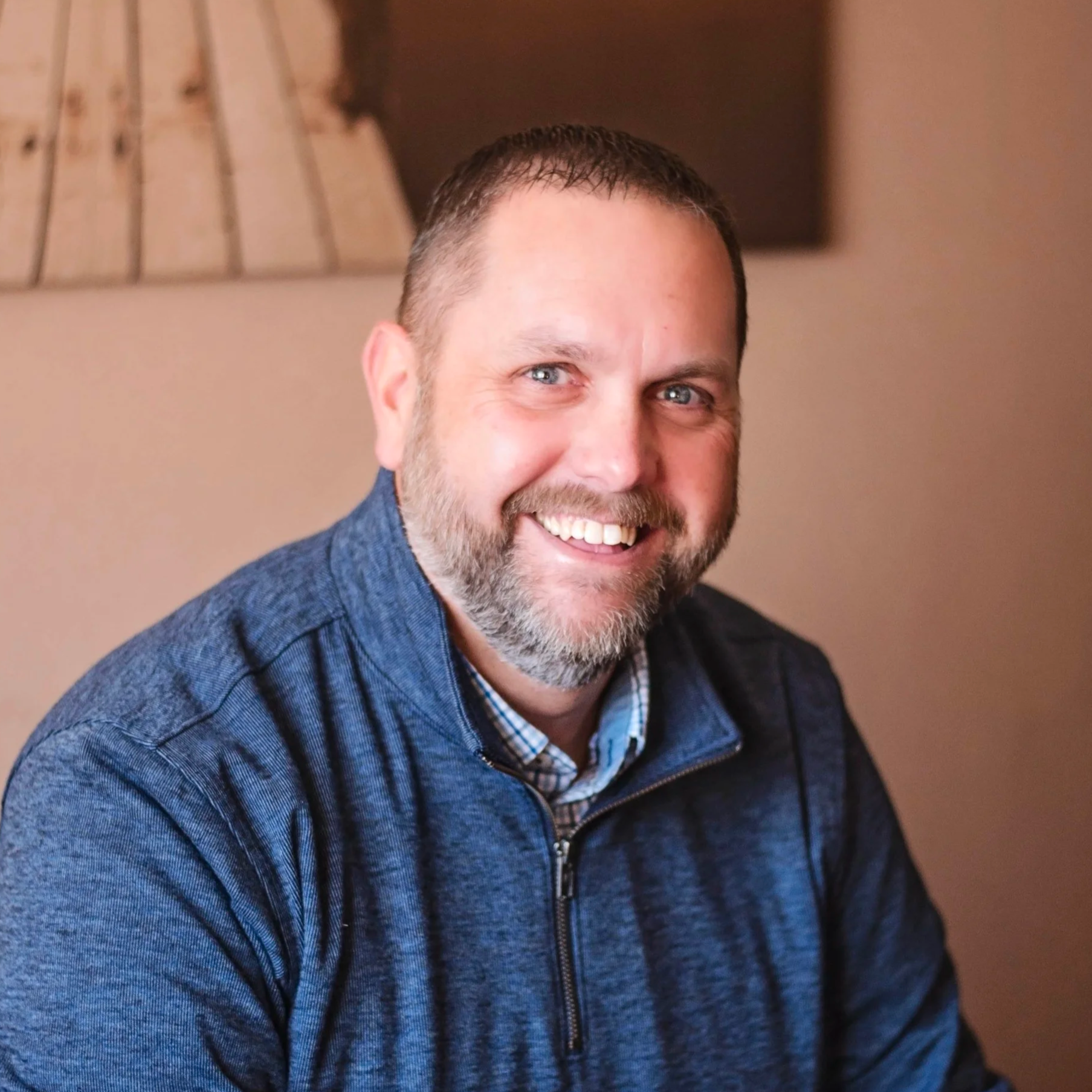 Robert Esselink, LPC. Man smiling with blue shirt, blue eyes.