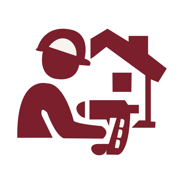 A person wearing a cap using a handheld tool in front of a house.