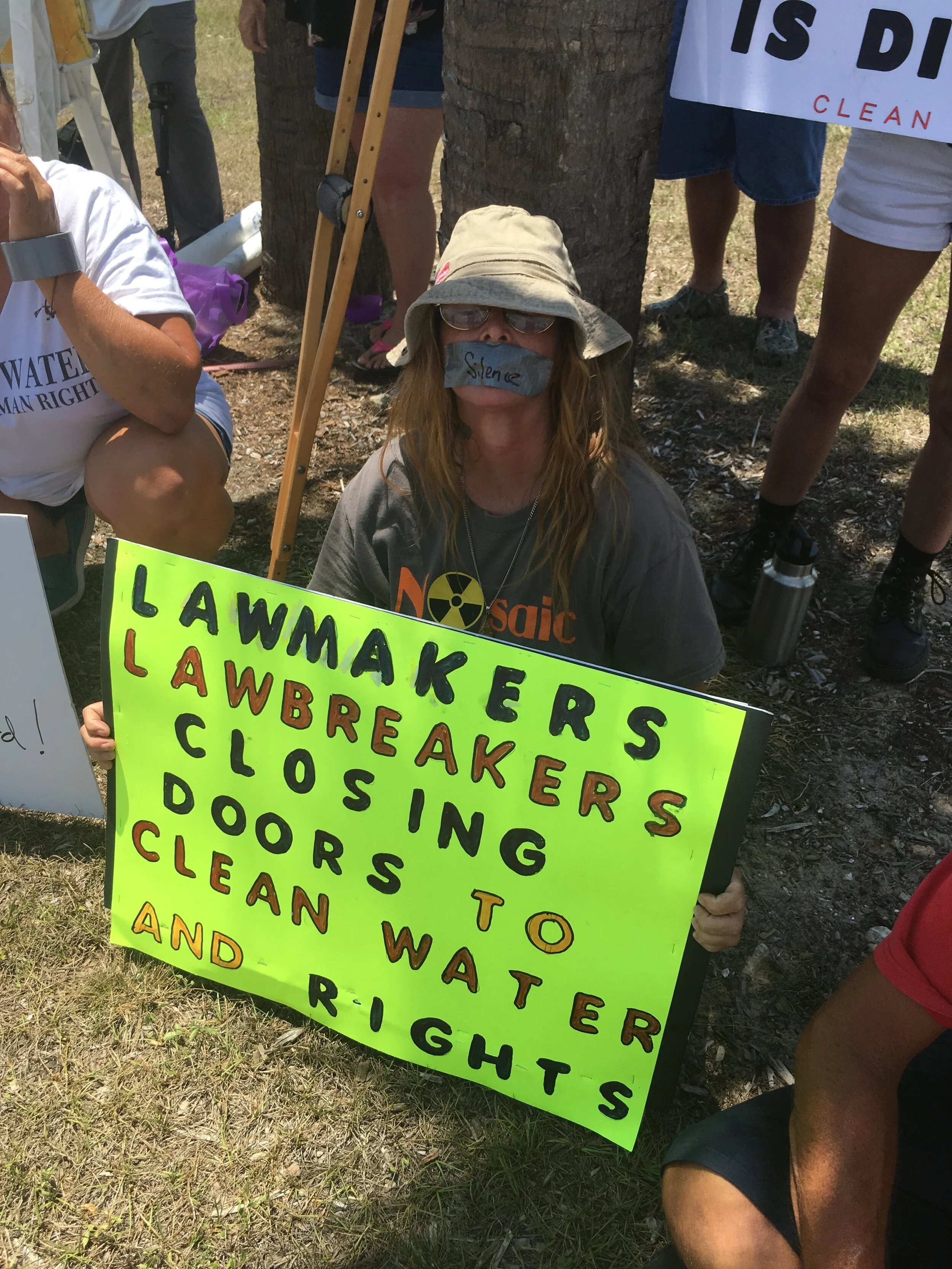 05-07-19-protester-with-taped-mouth-at-rooney-roundtable.jpg