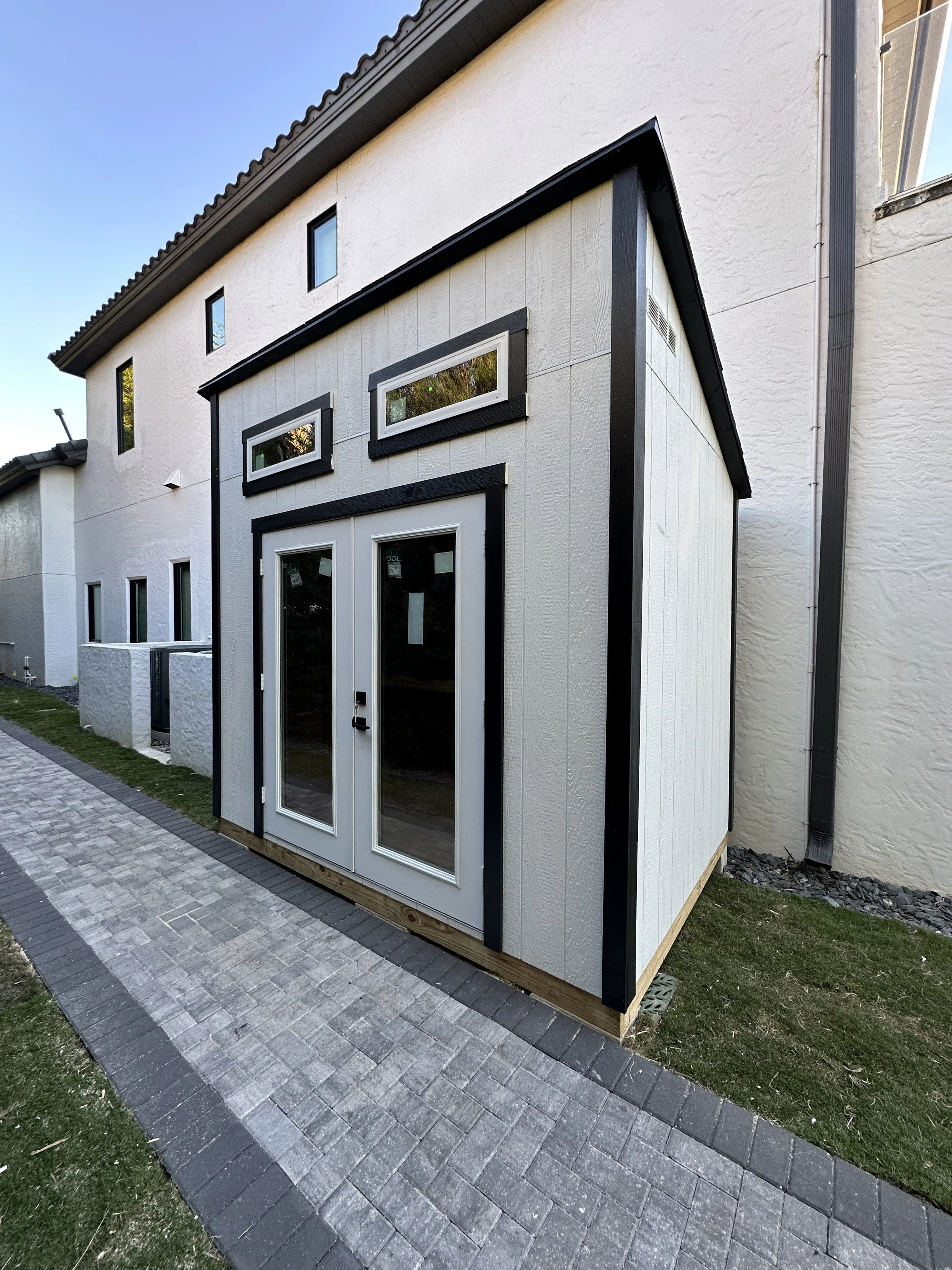 6x10 The Cove style (Lean to) with Custom Paint Job, residential doors and 2 transom windows.