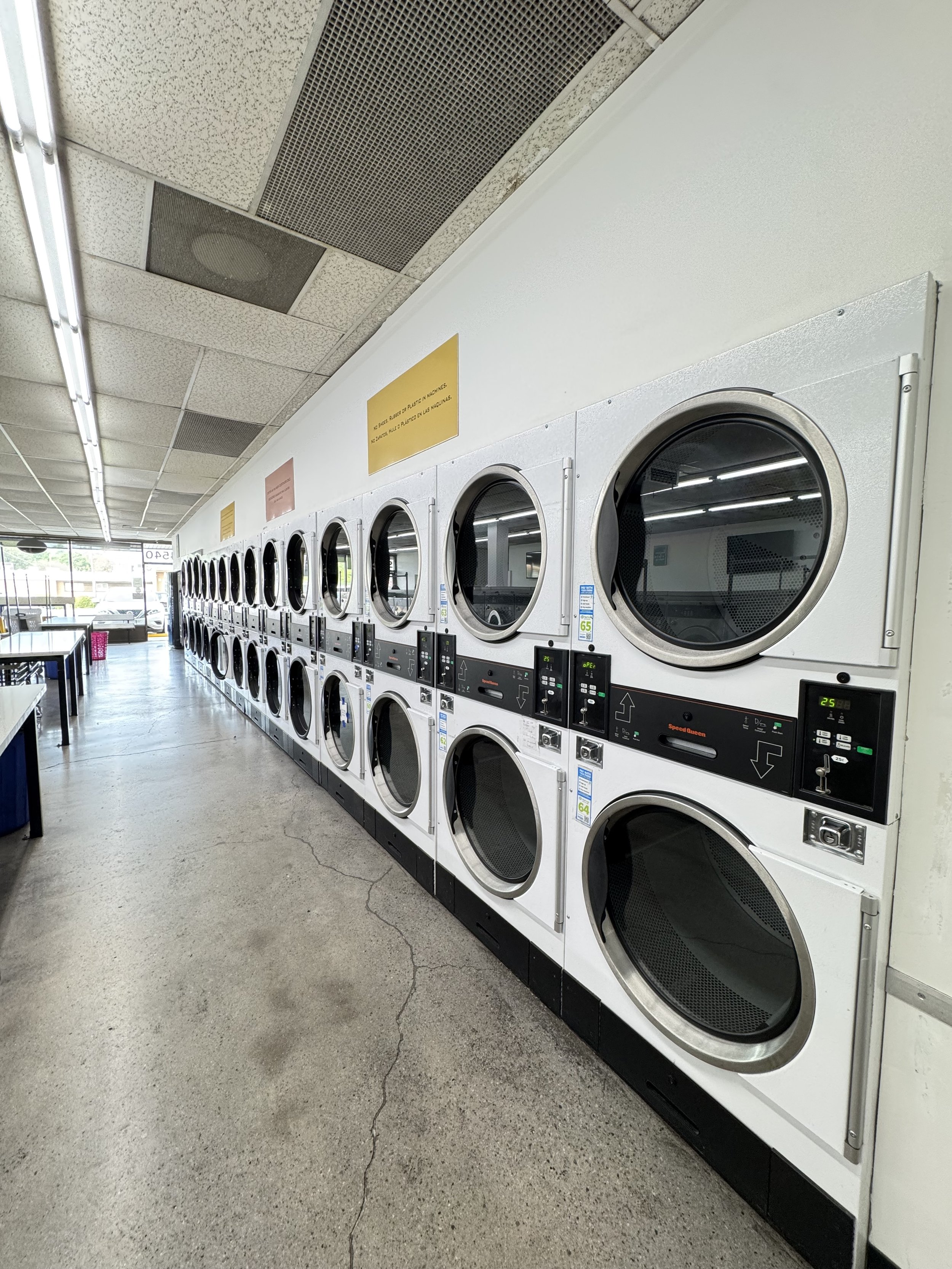 Row of commercial laundry dryers in a laundromat.