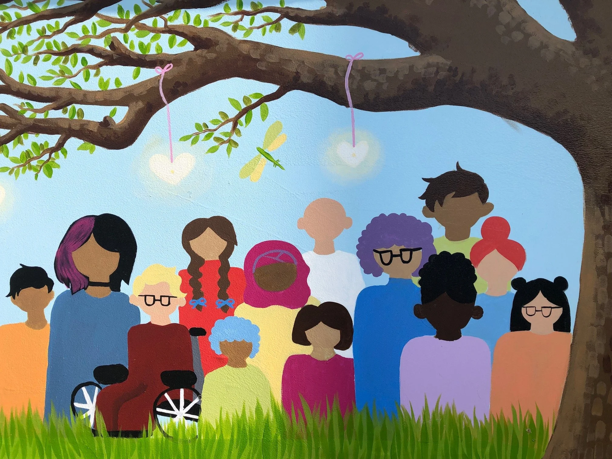 Left side of the Tree of Life mural at Blessingways Family Wellness in Airdrie, Alberta, showing people of diversity standing together under the spreading branches of the tree.
