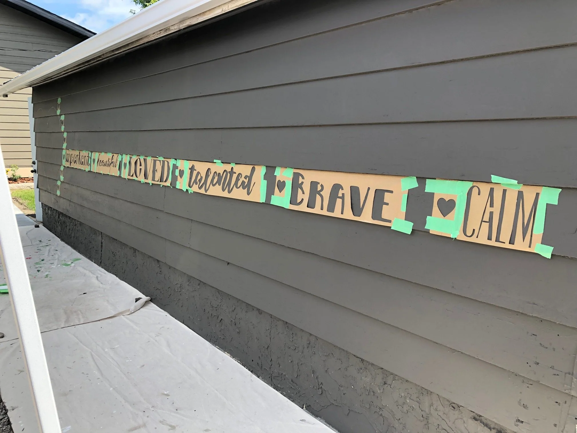 Beginning stage of the Affirmation Wall mural at Blessingways Family Wellness in Airdrie, Alberta, with base colors and design layout taking shape.