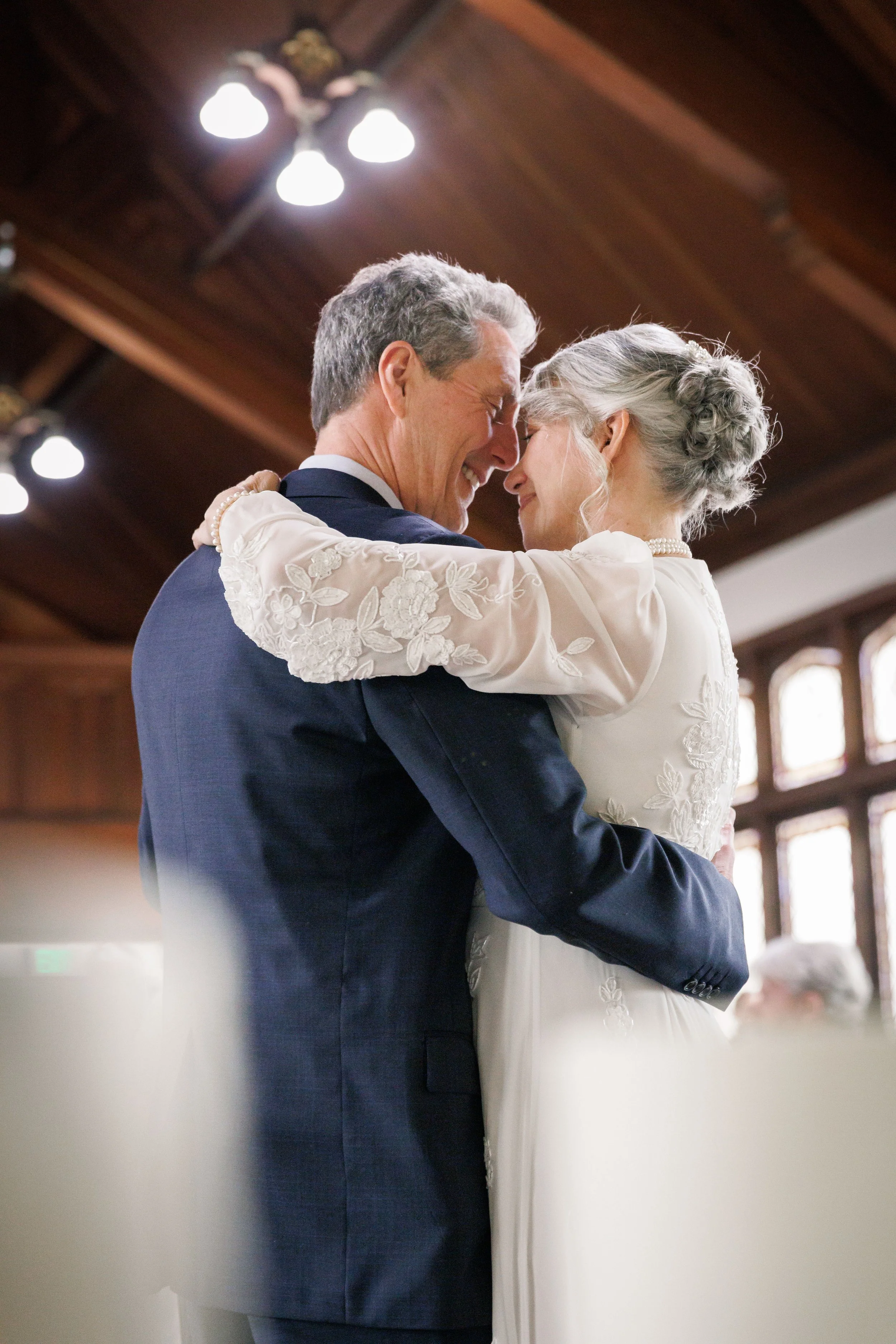 bride and groom embracing each other on the dance floor sharing a moment of love