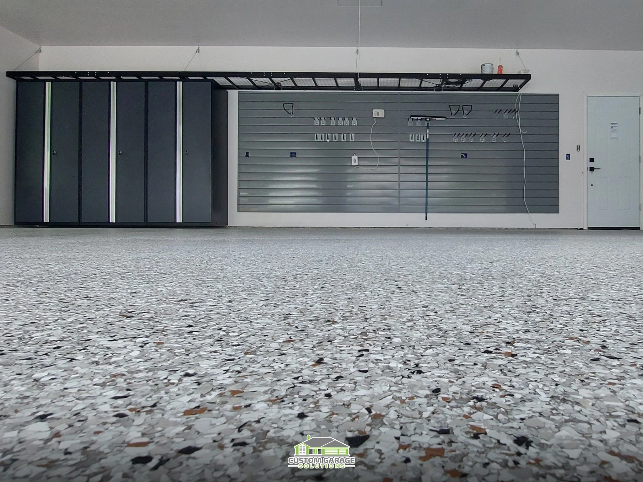 Slatwall, cabinets, and custom flooring to organize Colorado family sports equipment