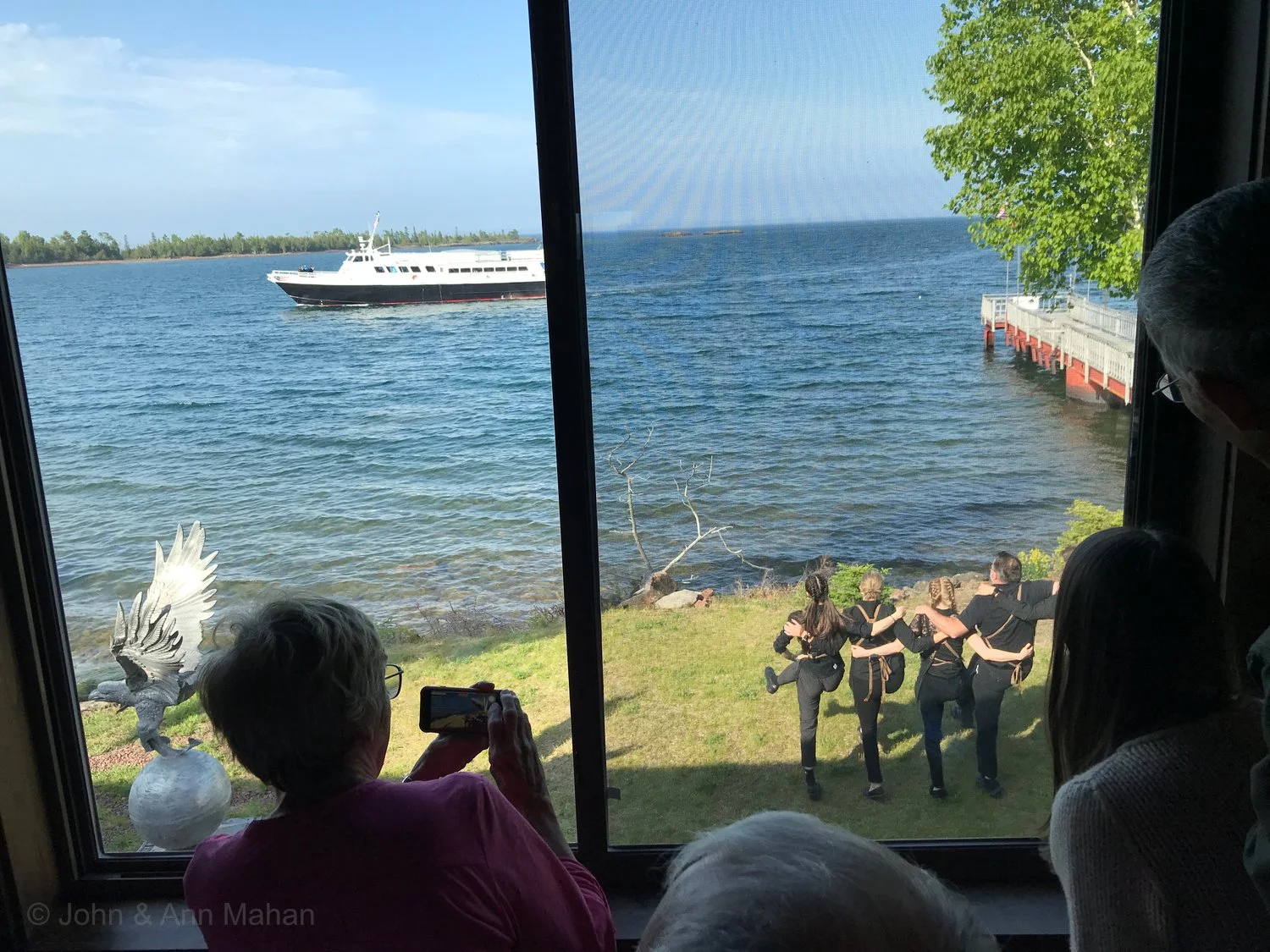 Keweenaw Peninsula Coach Tour -- Wait Staff at Harbor Haus Restaurant in Copper Harbor dancing for Isle Royale Queen ferry as it returns from Isle Royale
