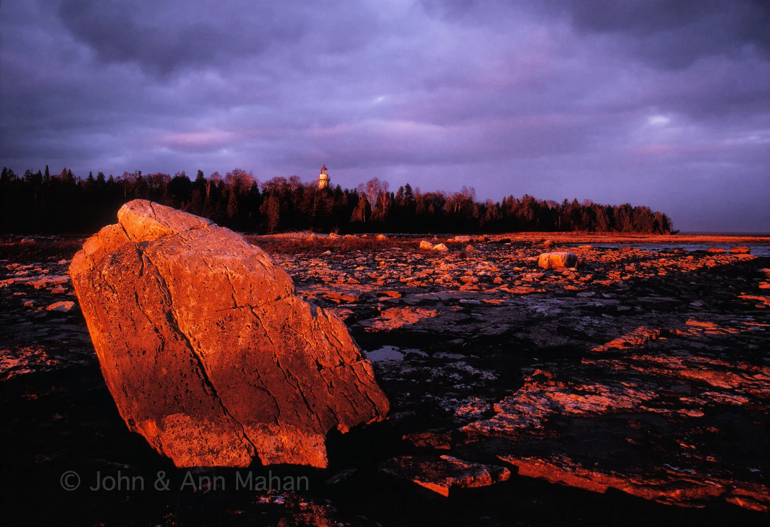 ID_30-4430C Last rays of sun on lakeshore boulder with Seul Choix Point Lighthouse in distance