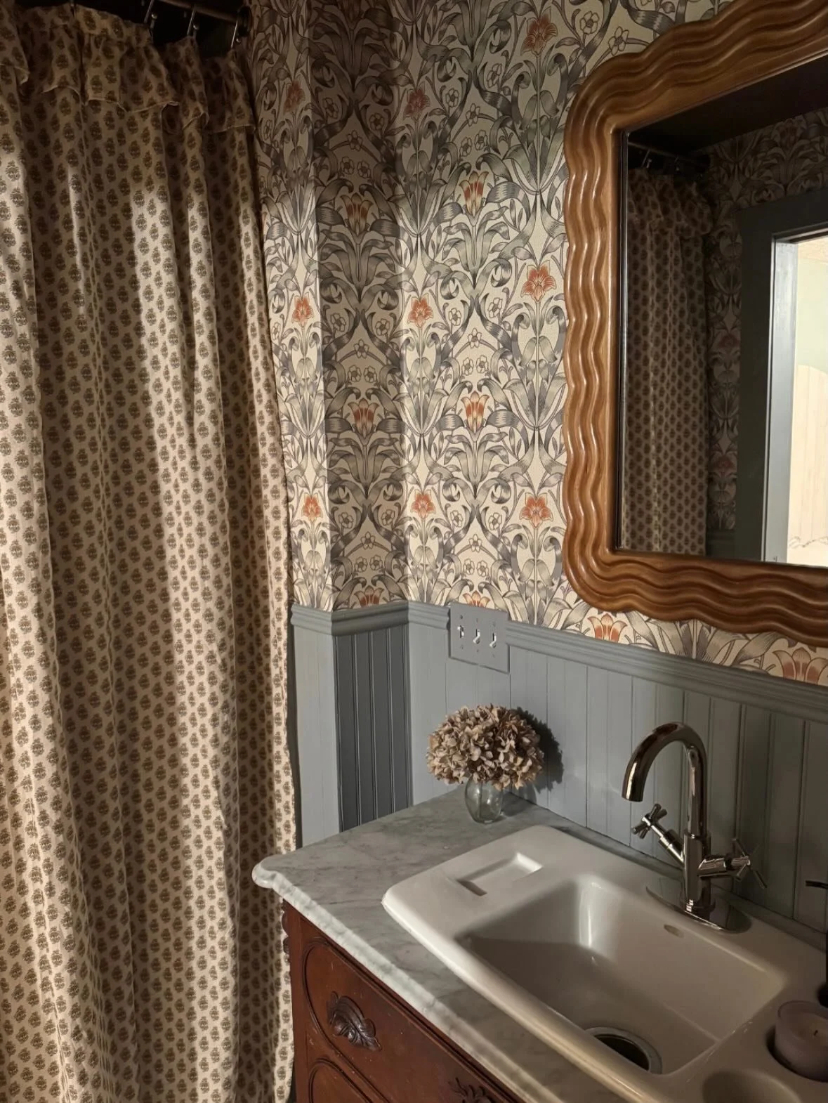 I recently updated one of our bathrooms with this absolutely stunning work of art from Mitchell Black - their Ribbon Lily wallpaper in the colorway Traditional Taupe. I wanted to find a wallpaper that worked well with the antique wood vanity and the 