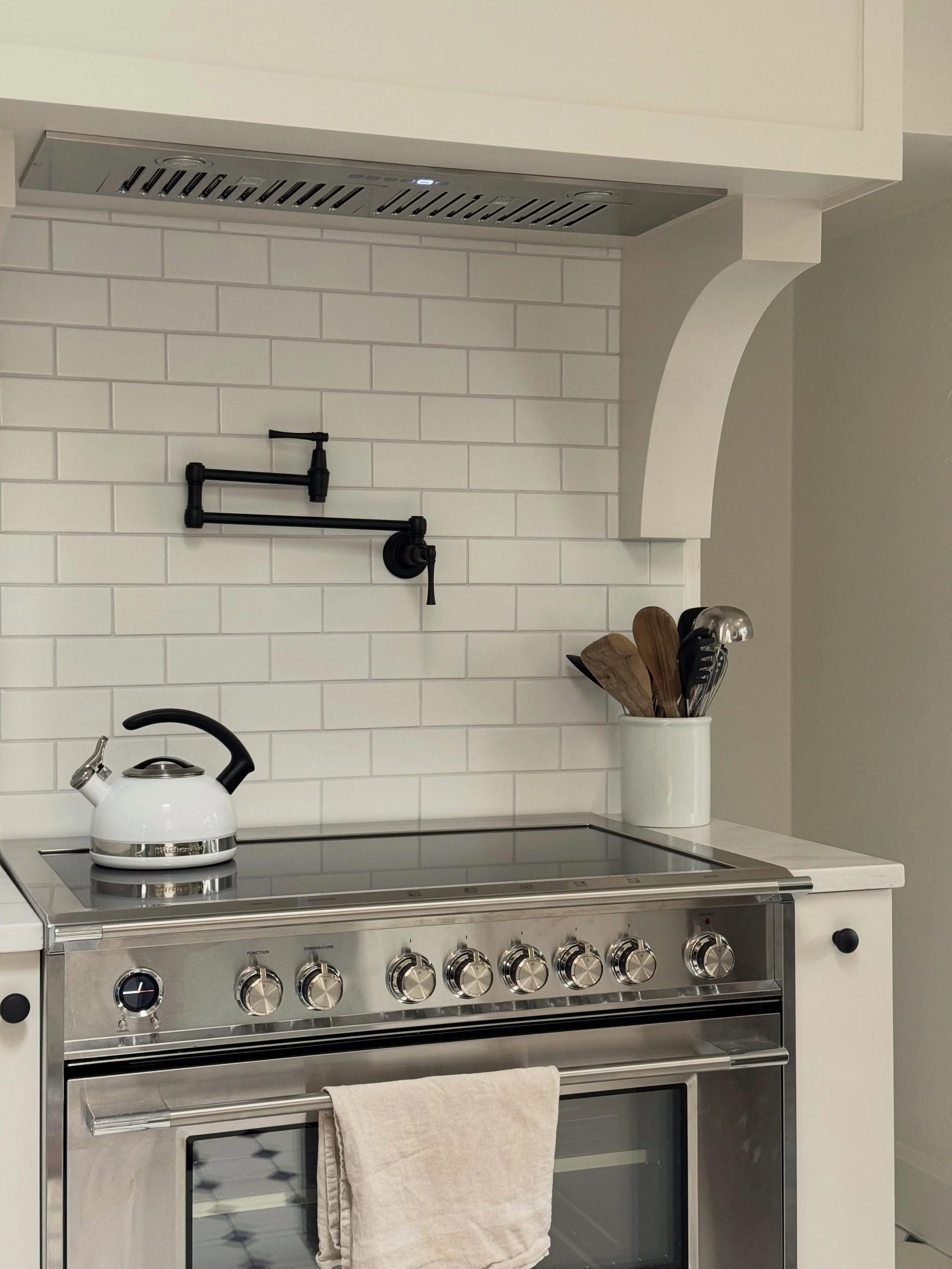 By upgrading to a true counter-depth fridge, moving it to the other side of the room and removing an old door frame and trim, we were able to create a dedicated cooking zone with a beautiful 36&rdquo; induction cook top and custom range hood. Small s