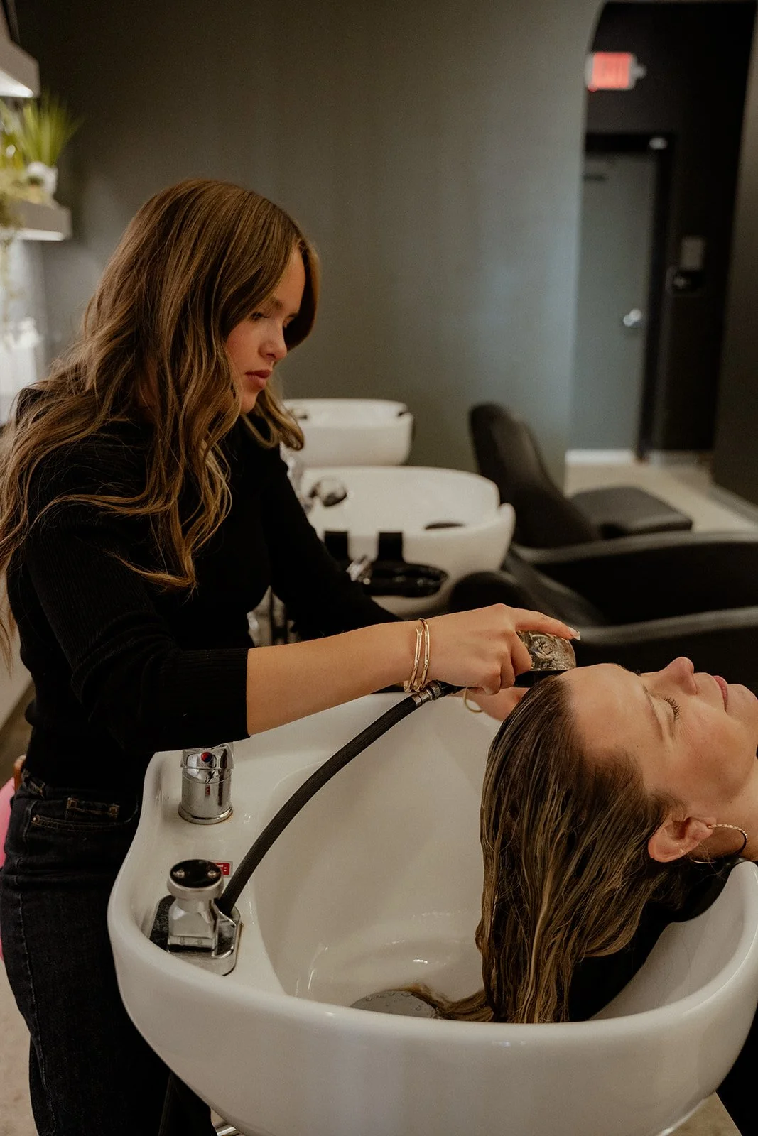 Client getting colored washed out at shampoo bowl at LB Extensions Salon.