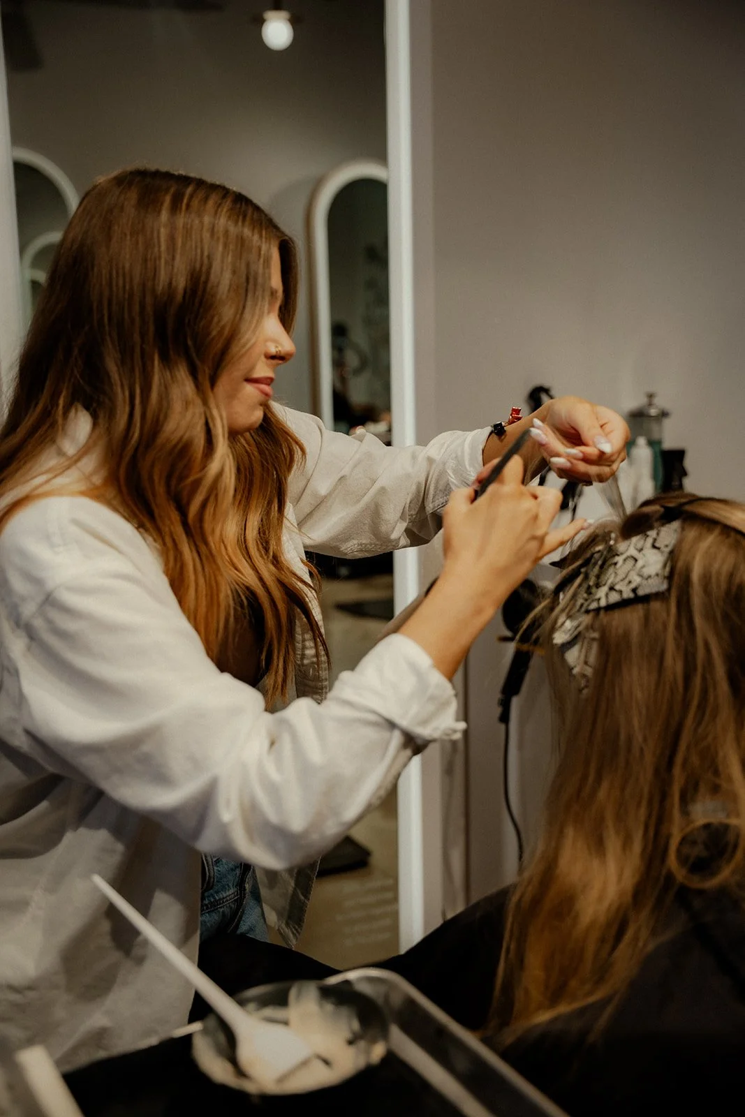 Stylist applies color using foils on client..