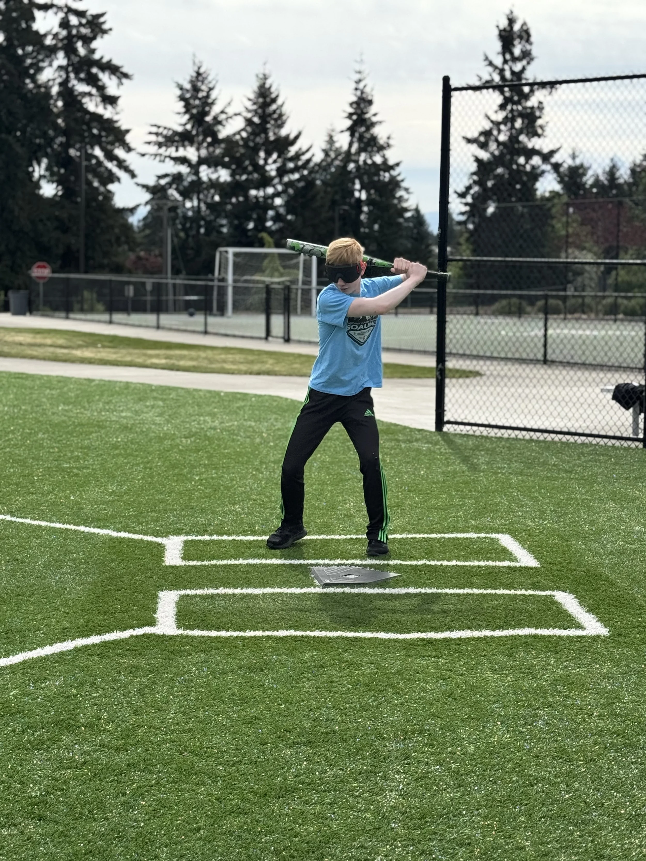 Beep baseball hitter up to bat, ready to swing and wearing an eye shade