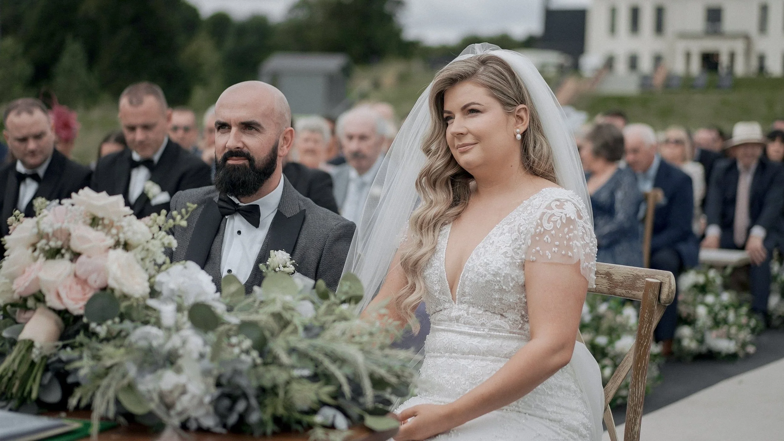Shona and Alan seated during their outdoor wedding ceremony at Glasson Lakehouse, Co. Westmeath