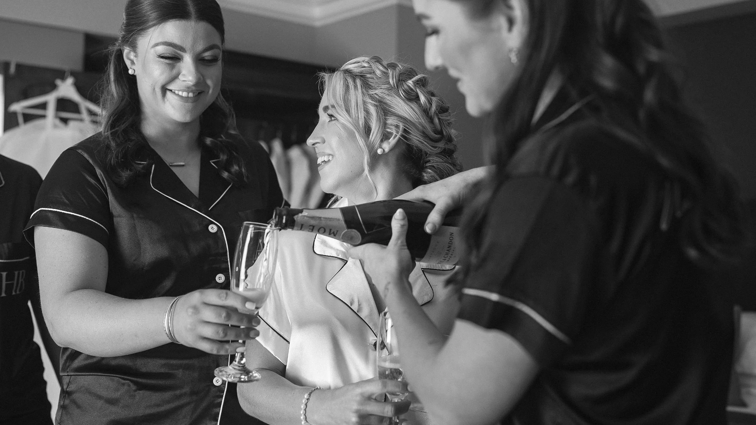Bridesmaids in black satin pyjamas pouring champagne for the bride at the Keadeen Hotel, Newbridge