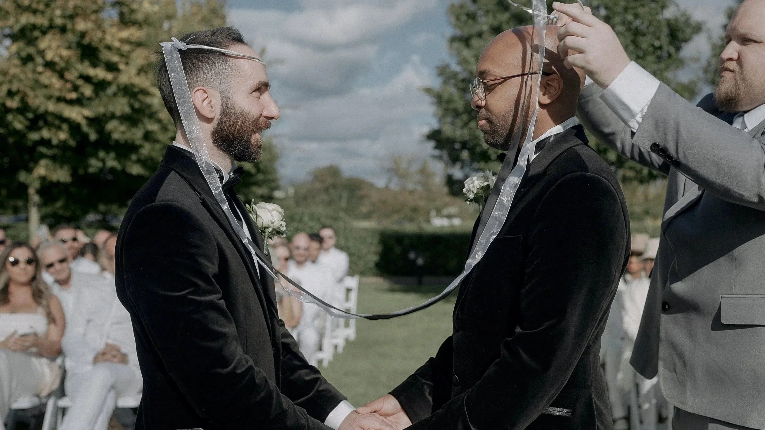 Celtic handfasting ceremony for Peris and Trevor in black velvet tuxedos at their Darver Castle wedding