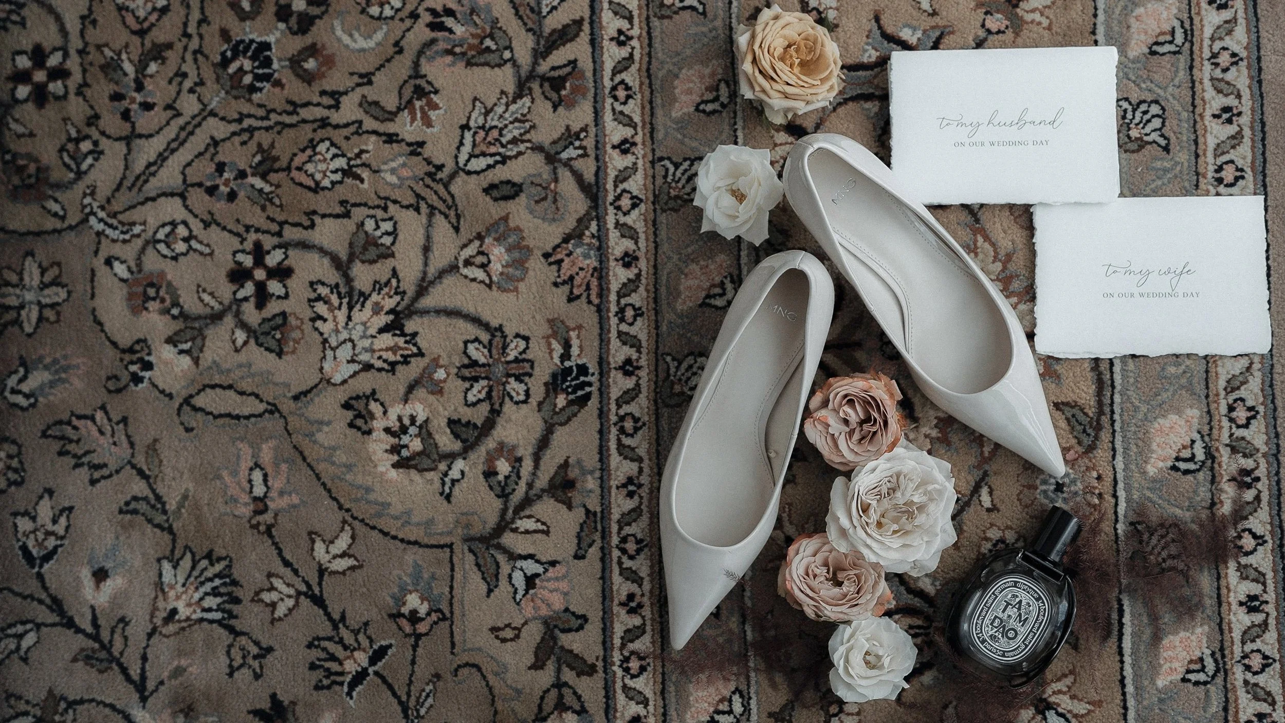 Bridal shoes, roses and handwritten wedding letters on a Persian rug at Kilkea Castle, Co. Kildare