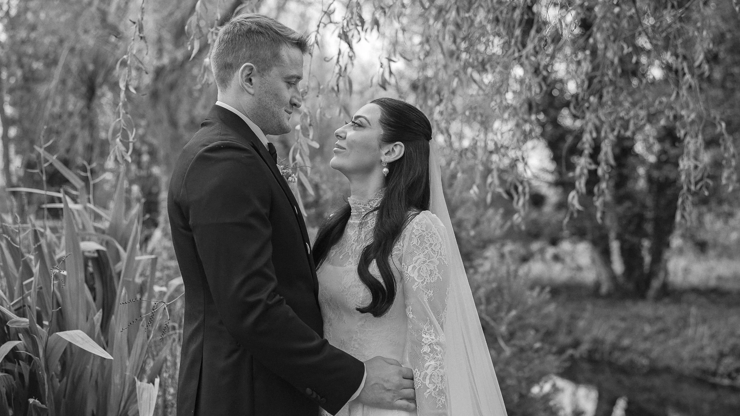 Black and white portrait of the bride and groom under a weeping willow at Kilkea Castle