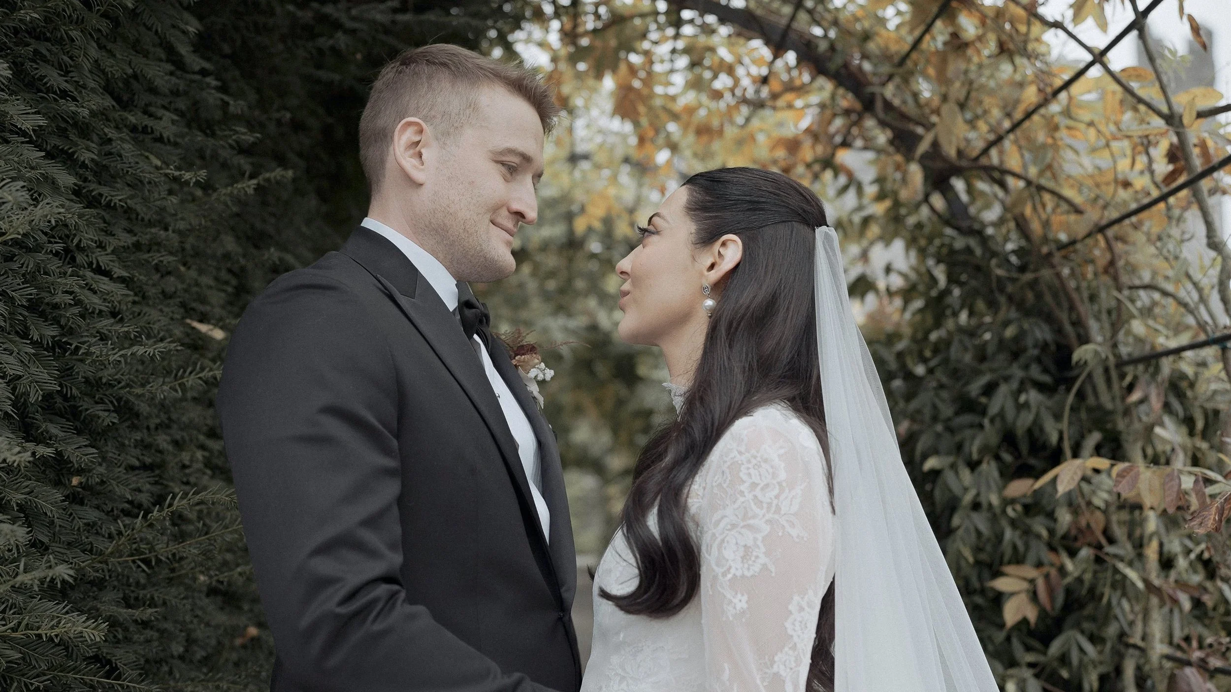 Bride and groom under golden autumn leaves in the gardens of Kilkea Castle