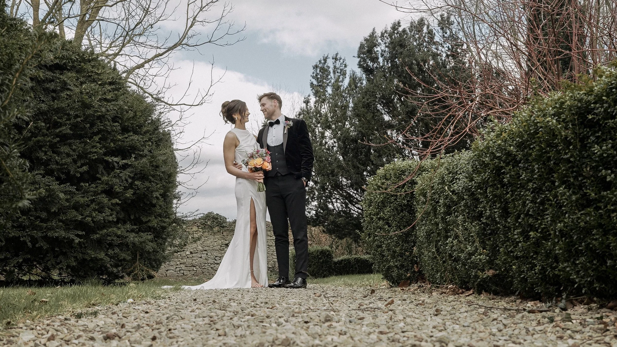 Bride and groom between yew hedges in the gardens of Barberstown Castle