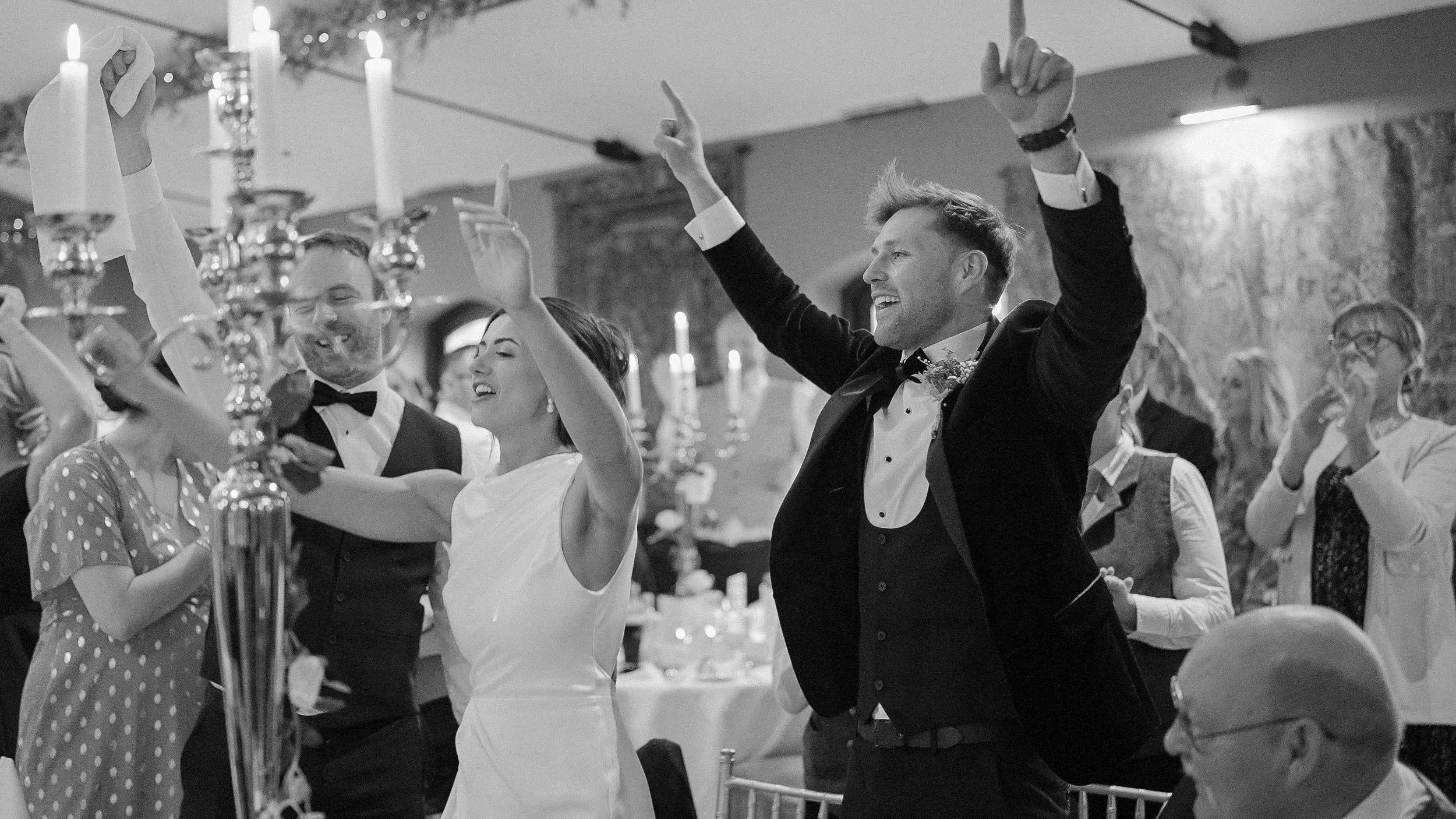 Bride and groom celebrating with arms in the air at their wedding reception at Barberstown Castle