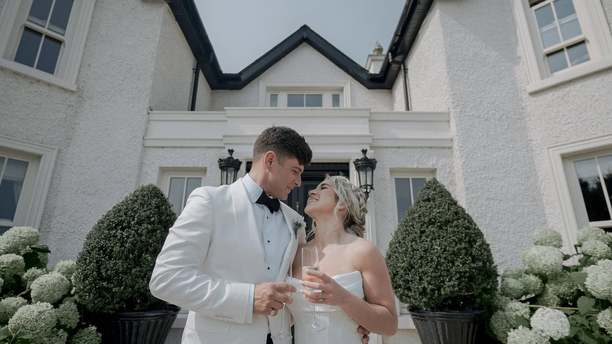 Bride and groom with champagne on the steps of their family home, Curragh wedding in Kildare