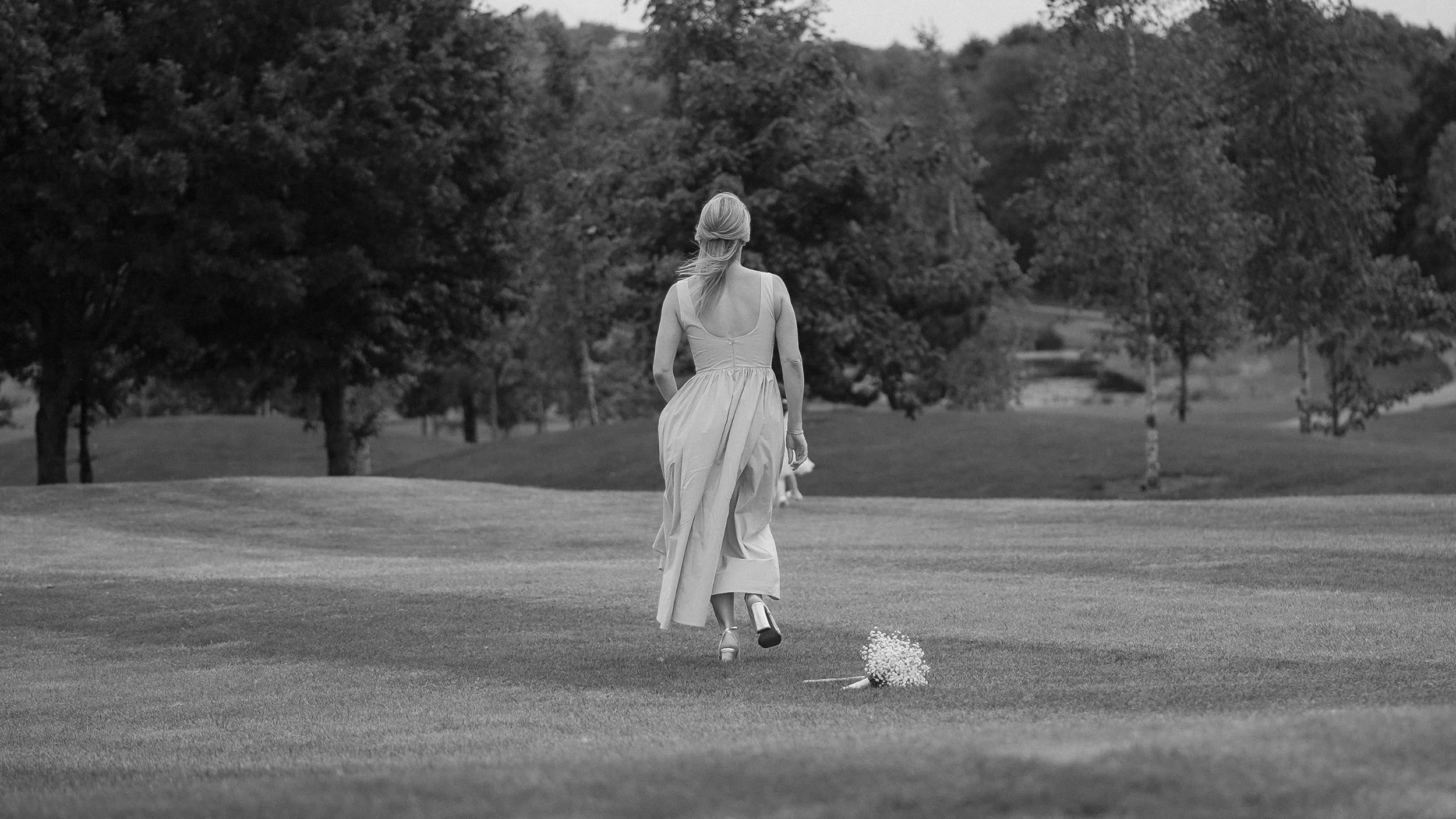 Bridesmaid walking across the golf course at Glasson Lakehouse, Co. Westmeath