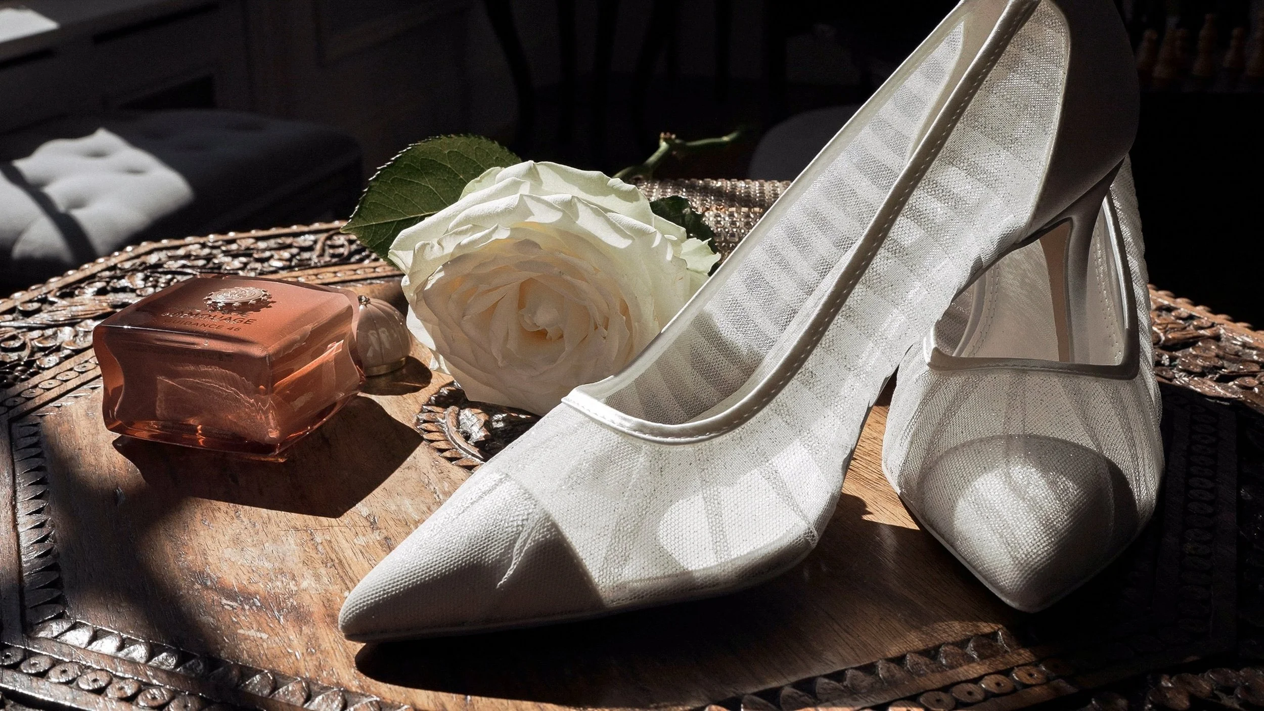 Bridal heels, perfume and a white rose on a carved table at Clonwilliam House, Wicklow
