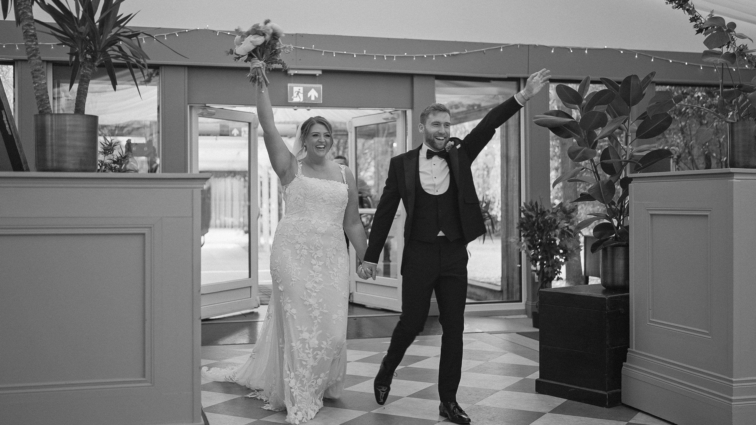 Bride and groom cheering as they enter their wedding reception at Tinakilly Country House, black and white