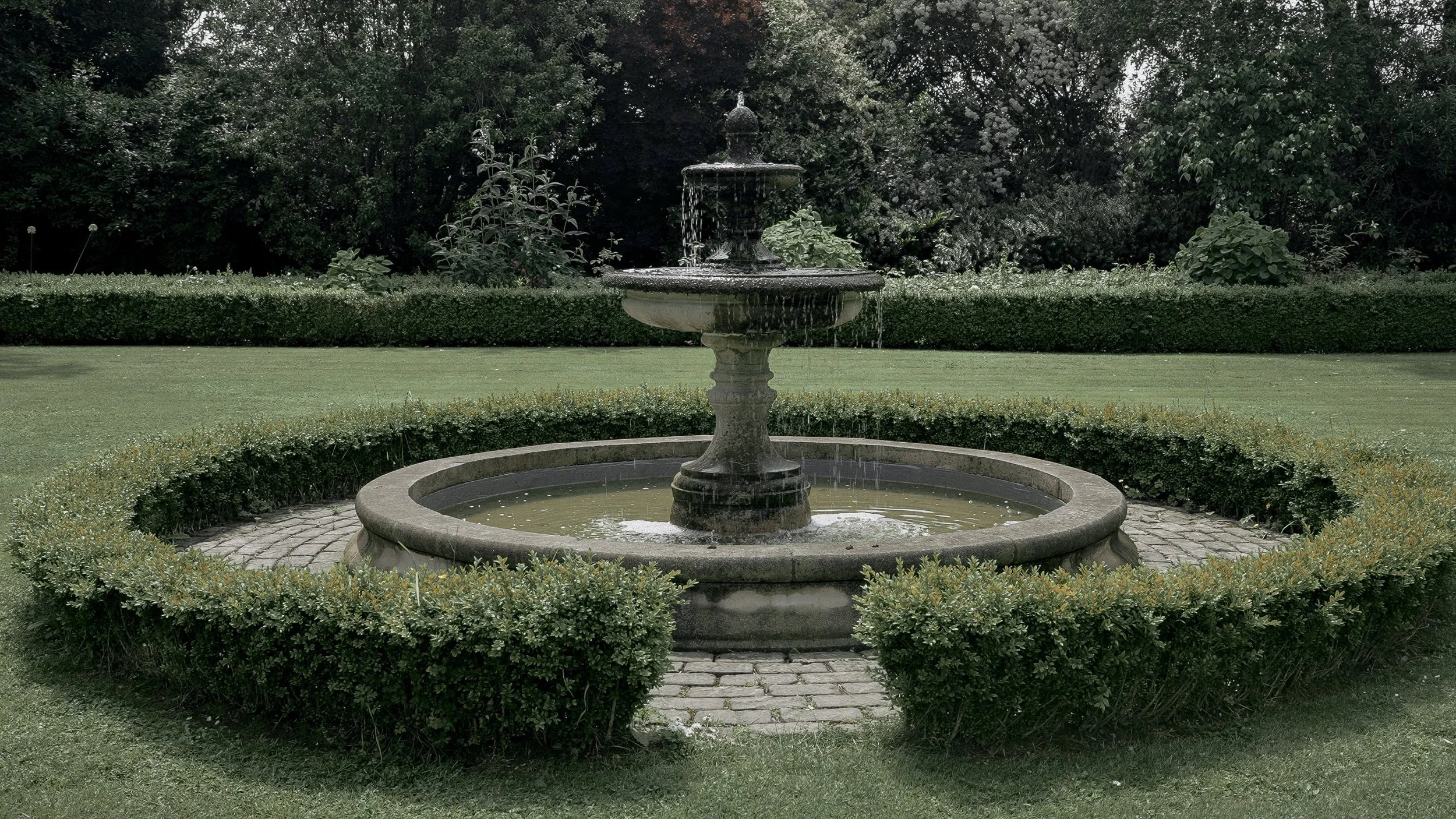 Stone fountain and box hedges in the formal gardens of Tinakilly Country House, Co. Wicklow