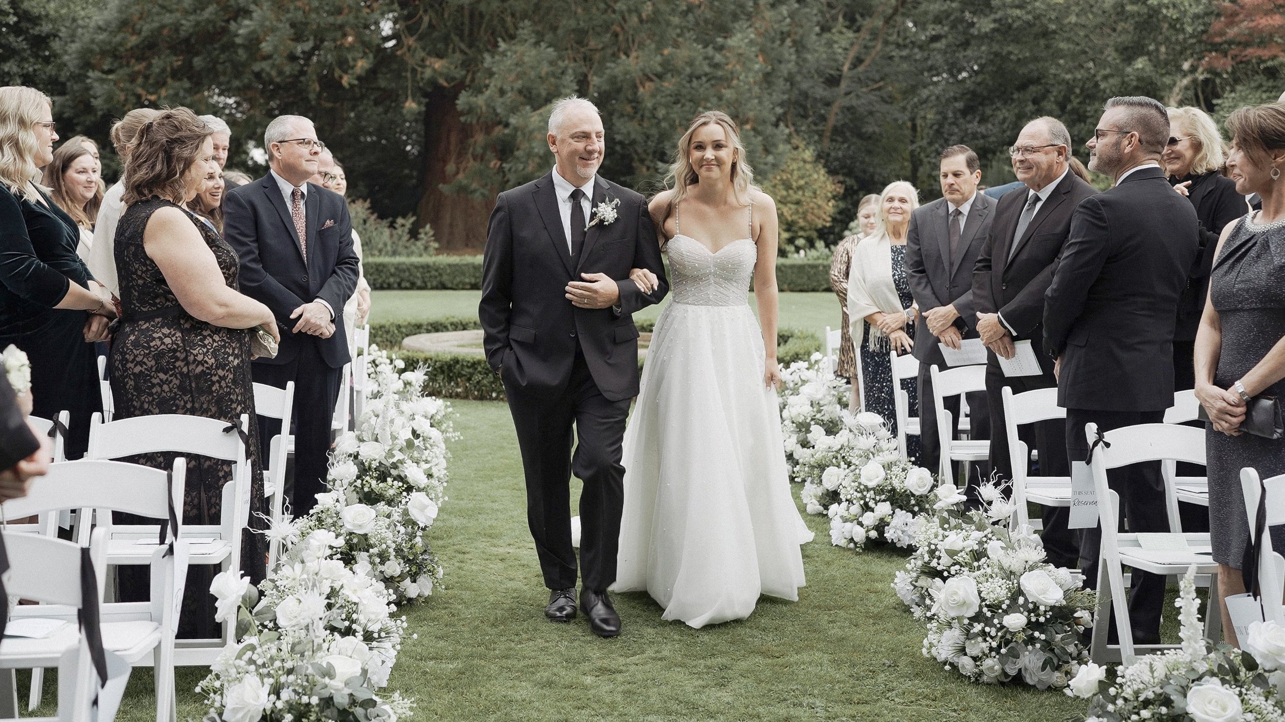 Bride walking down the aisle with her father at an outdoor Tinakilly House wedding ceremony