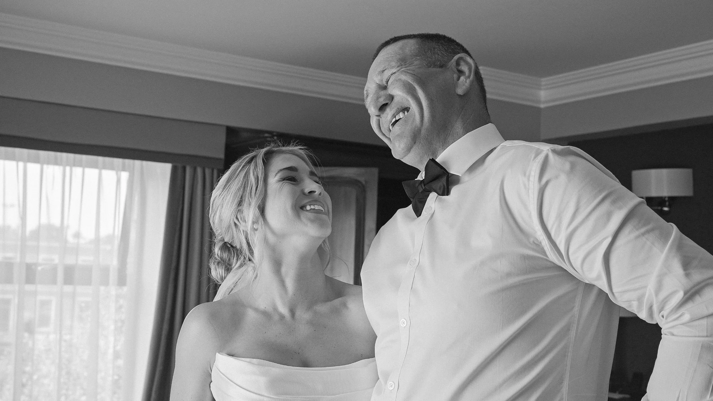 Bride laughing with her father on the morning of her Curragh wedding in Kildare