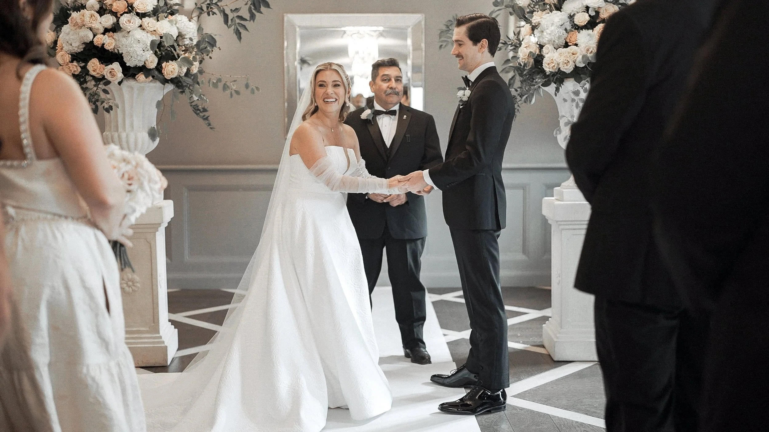 Smiling bride holding hands with the groom during their wedding ceremony at Kilkea Castle, Co. Kildare