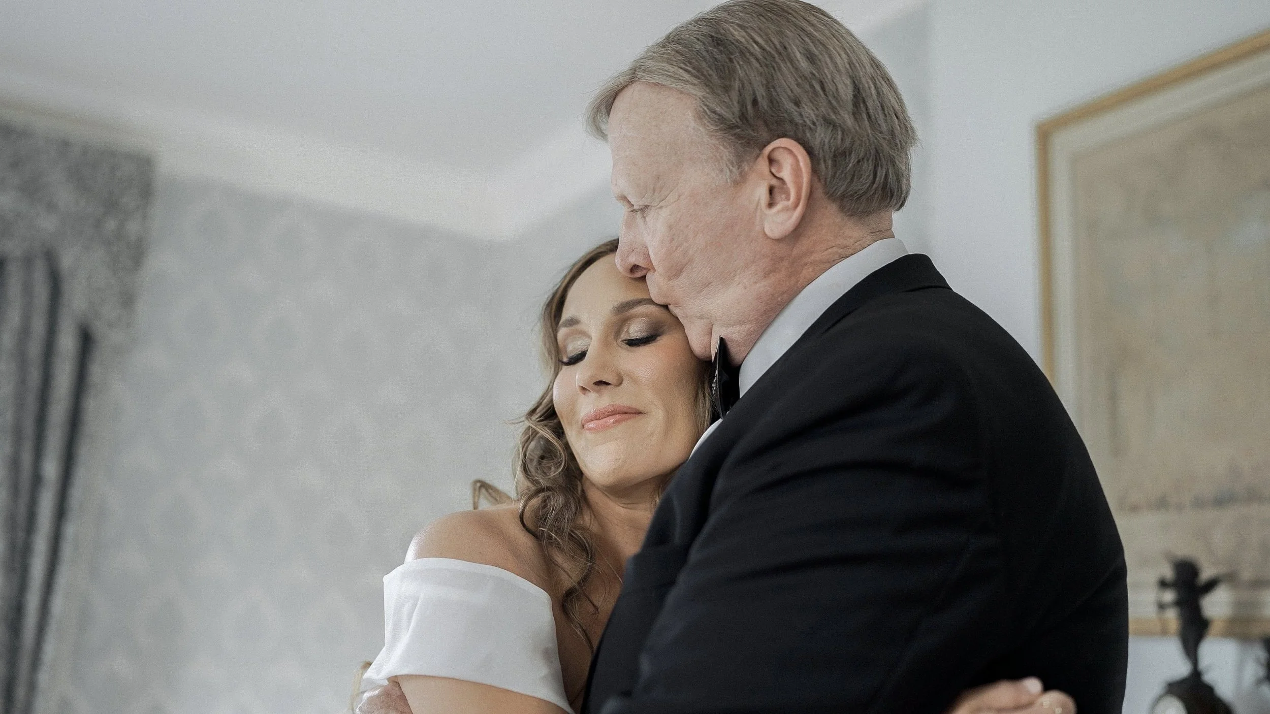 Father of the bride hugging and kissing his daughter on the forehead before the ceremony at Waterford Castle