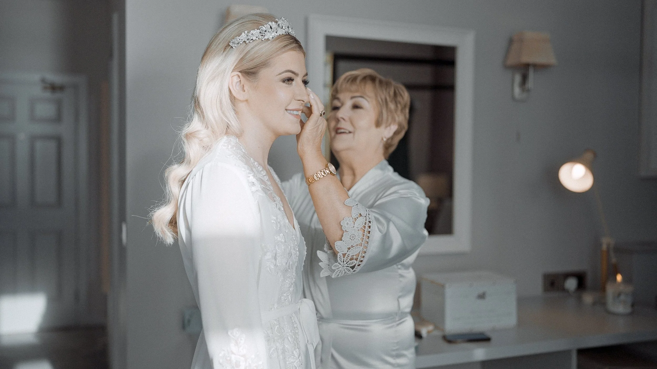Bride Hannah's mother putting in her earrings while getting ready for her Armada Hotel wedding in Spanish Point