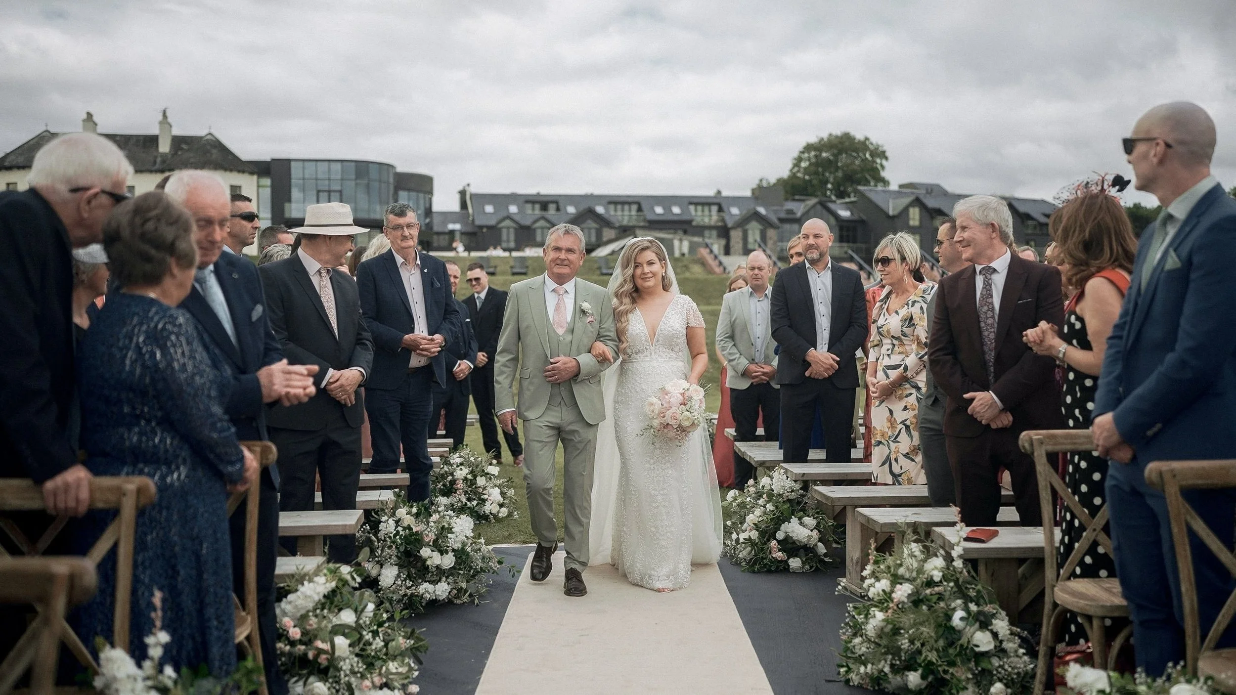 Bride walking down the aisle with her father at an outdoor ceremony at Glasson Lakehouse, Athlone
