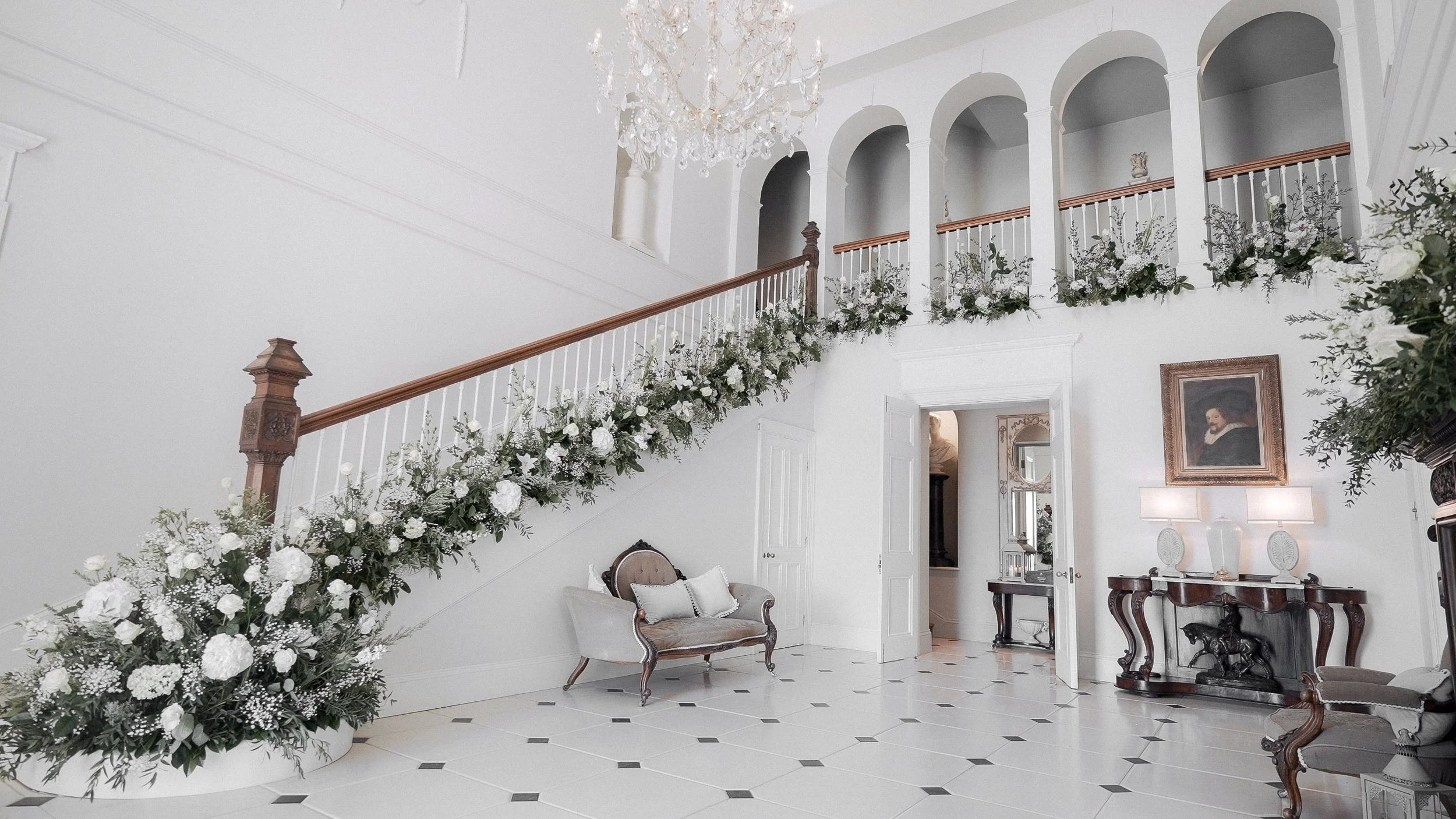 Grand hall staircase dressed with white wedding flowers at Clonwilliam House, Co. Wicklow