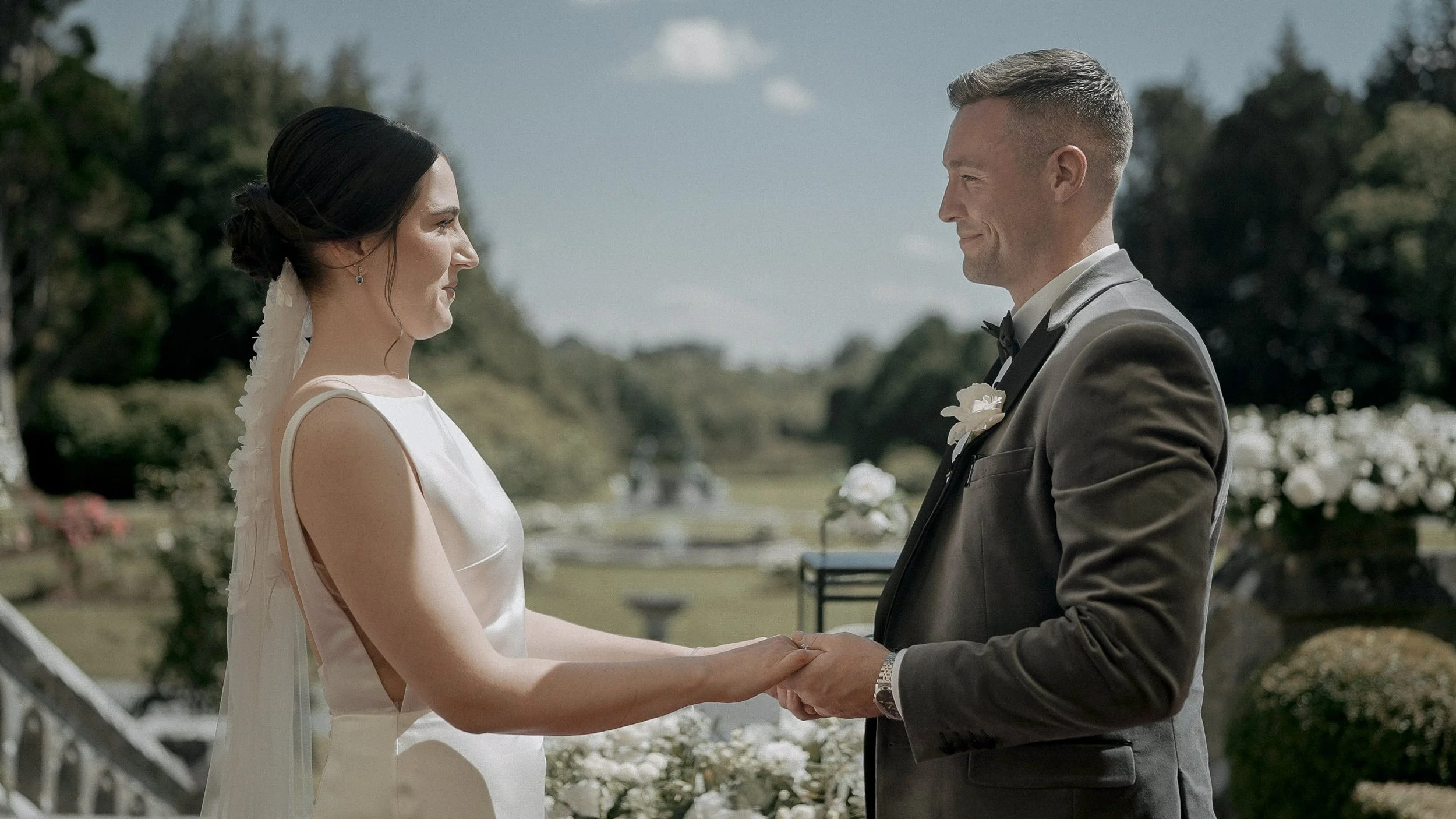 Bride and groom holding hands during their outdoor ceremony on the terrace at Markree Castle, Co. Sligo