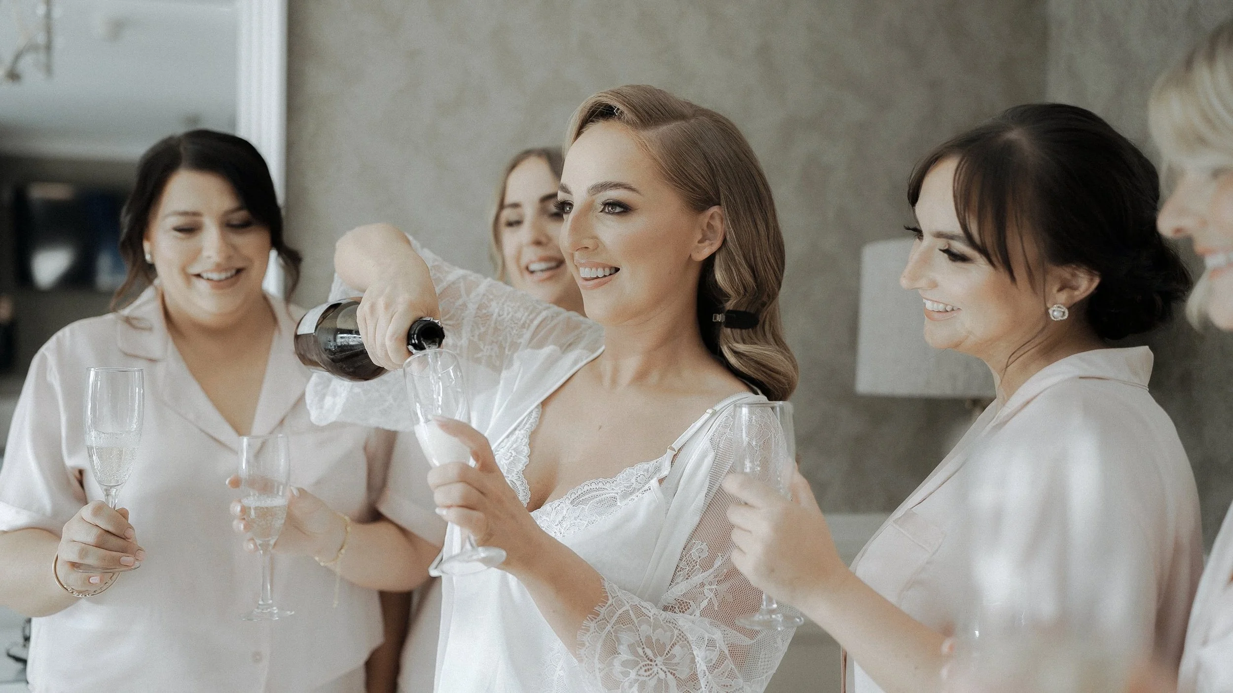 Bride pouring prosecco for her bridesmaids before her Crover House Hotel wedding in Co. Cavan