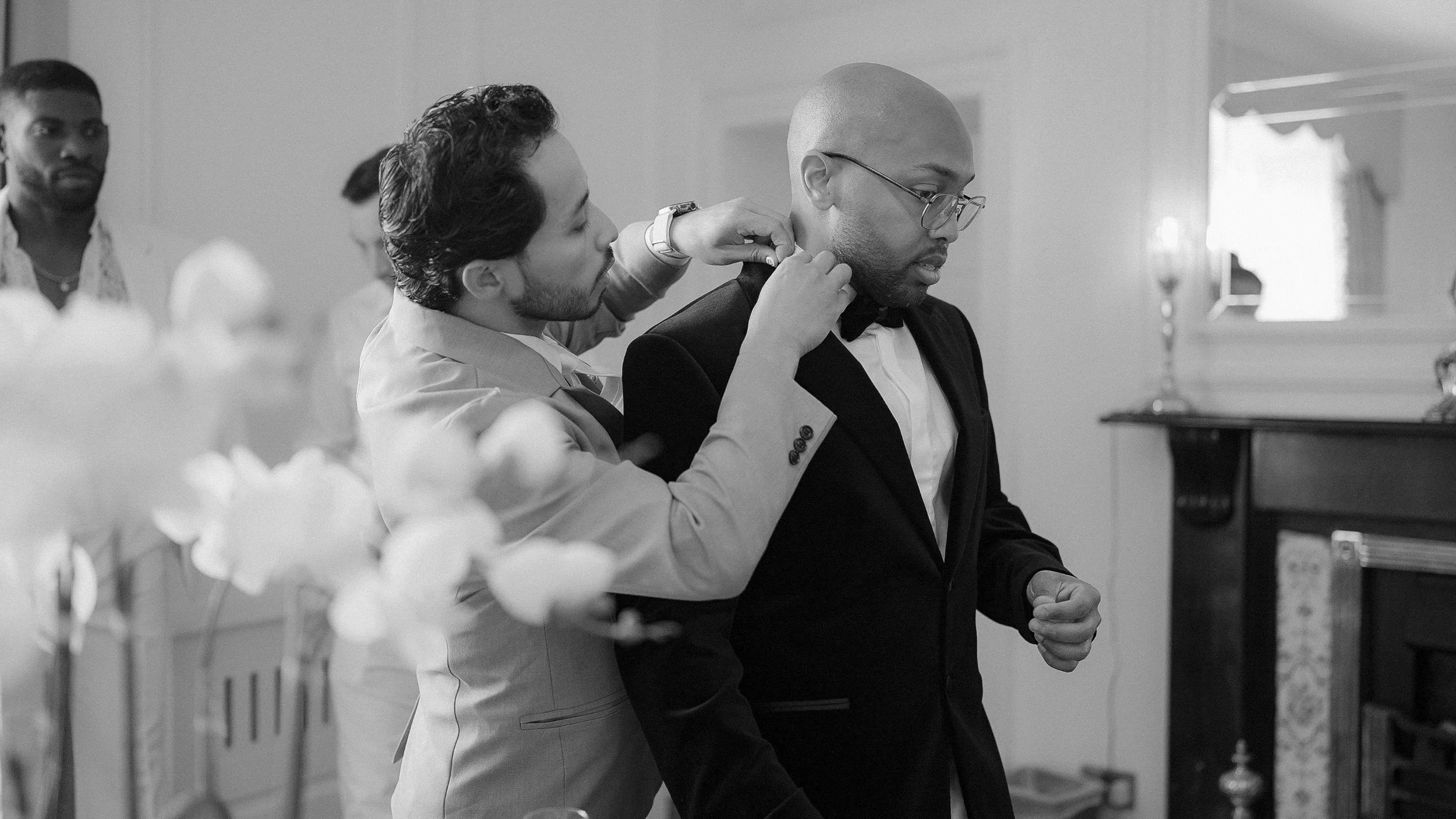 Black and white photo of the grooms getting ready with a groomsman inside Darver Castle, Co. Louth