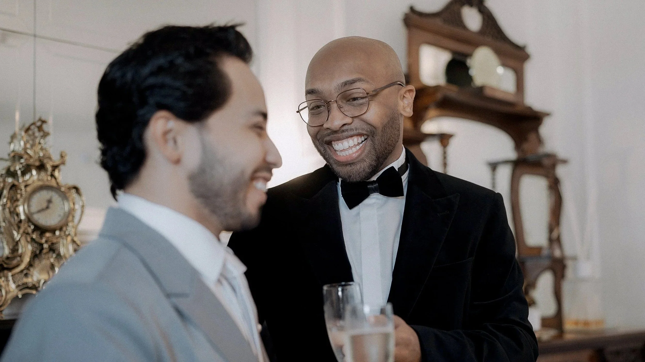 Groom smiling with a glass of champagne while getting ready for his Darver Castle wedding