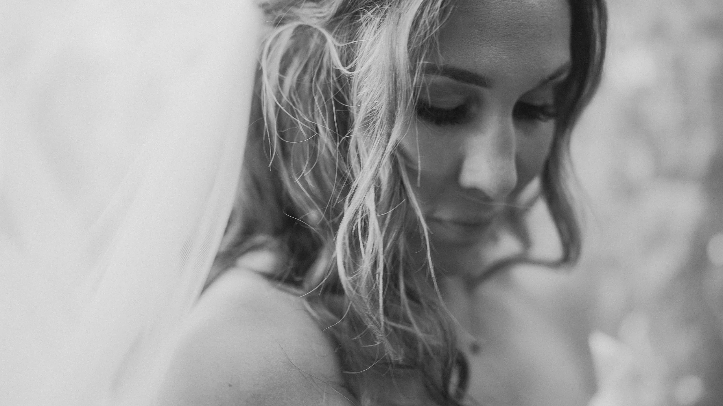 Close-up of the bride with her veil and loose curls at Waterford Castle, black and white