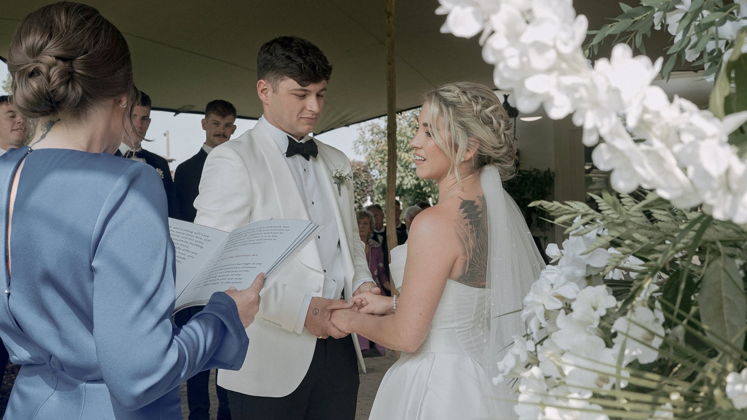 Taylor and Jack holding hands during their garden wedding ceremony at a family home on The Curragh, Co. Kildare