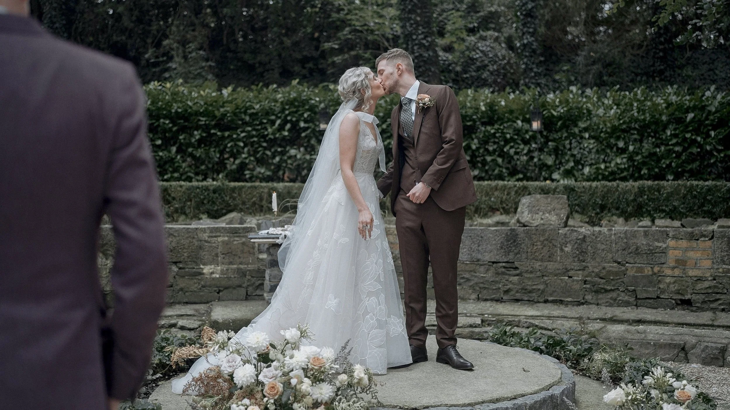 First kiss at an outdoor wedding ceremony in the stone garden of the Station House Hotel, Co. Meath